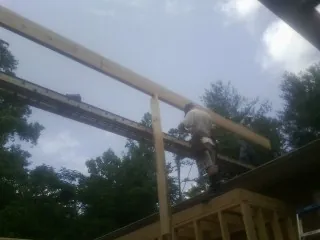 Carpenter setting a ridge beam over a new addition frame — Ice Dam Removal by Roofing Brothers in Sandy Lake