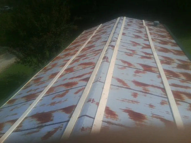 Rusted metal roof panels with new wood purlins before replacement — Storm Damage Roof Repair in Sandy Lake by Roofing Brothers