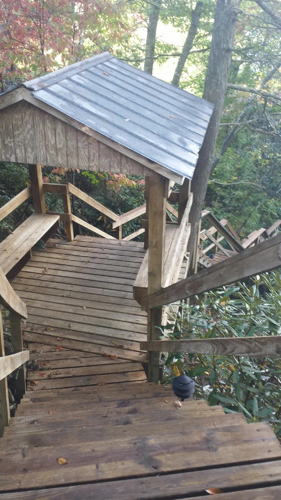 Metal roofed shelter over wooden steps on a wooded walkway — Skylight Repair & Installation work by our crew in Sandy Lake