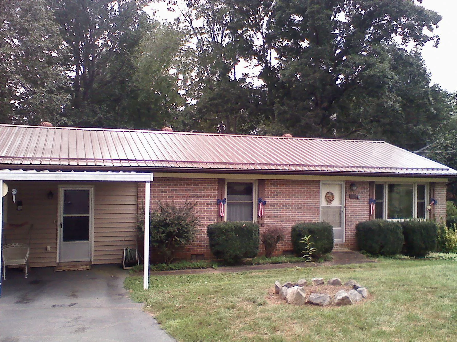 Bronze metal roof and carport on a brick ranch home — Roof Repair work by our crew in Sandy Lake
