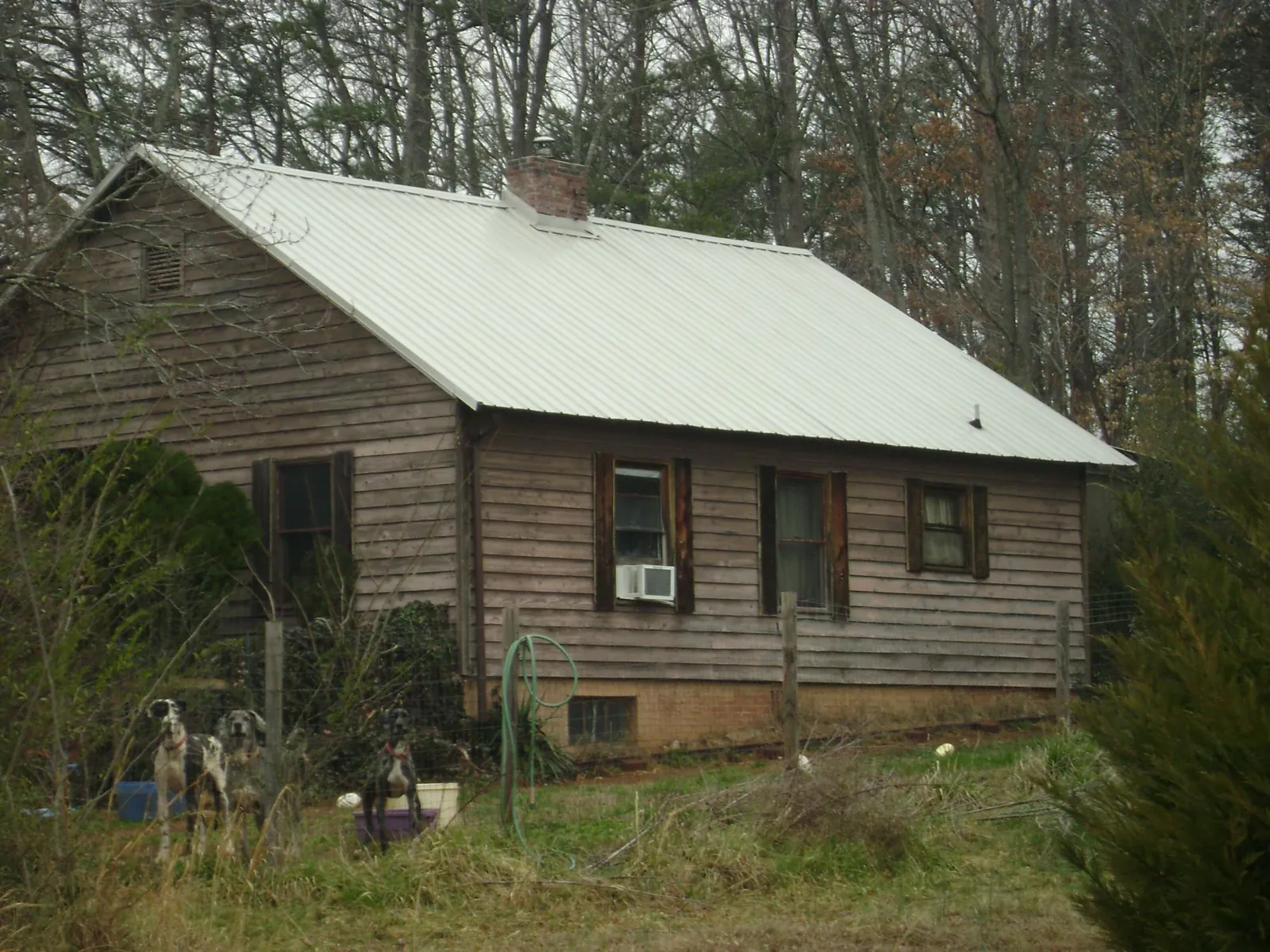 White metal roof on an old wood sided farmhouse, from a Metal Roof Installation job in Sandy Lake